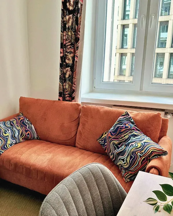 Pomarańczowa sofa w gabinecie w Śródmieściu.