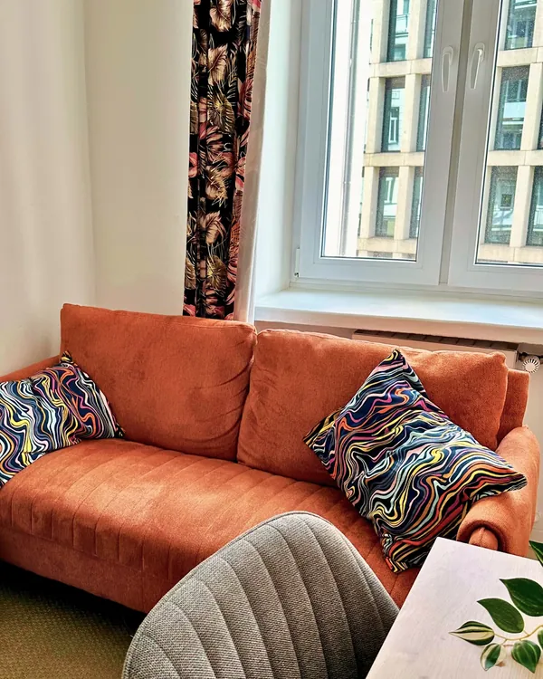 Pomarańczowa sofa w gabinecie w Śródmieściu.